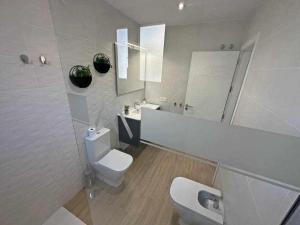 a white bathroom with a toilet and a sink at XXII Apartamentos Morales&Arnal in Estepona +28 photos