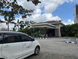 a white car parked in front of a building at ILLIRA Lite Praya Lombok in Praya
