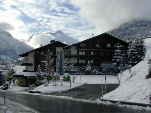 un lodge dans les montagnes avec de la neige au sol dans l'établissement Suitehotel Kleinwalsertal, à Hirschegg