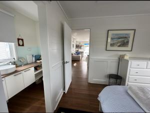 a white kitchen with a sink and a bed in a room at Elegant and scenic floating boat house in Kettering