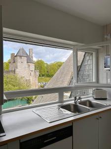 a kitchen window with a sink and a castle at LAROCHE Grand duplex dans le centre historique avec garage in Vannes