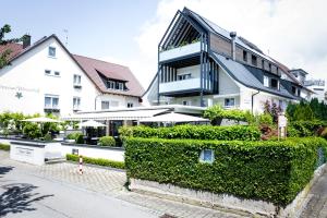 un edificio con una siepe verde di fronte a un edificio di Hotel Hagnauer Seeperle a Hagnau