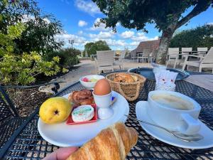 a table with a cup of coffee and a plate of food at Hôtel Les Vieilles Tours Rocamadour in Rocamadour