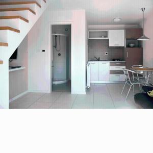 a kitchen with white cabinets and a table and a staircase at Apartments Villa Ina in Brseč +72 photos