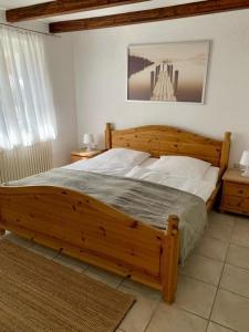 a bedroom with a large wooden bed with white pillows at Haus Alkmene in Bodman-Ludwigshafen