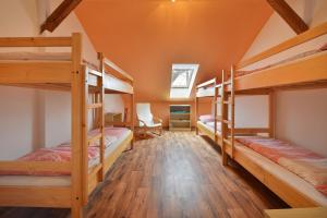 a room with four bunk beds in a house at Hostel Hluboká in Hluboká nad Vltavou