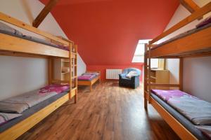 a room with two bunk beds and a chair at Hostel Hluboká in Hluboká nad Vltavou