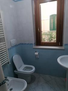 a bathroom with a toilet and a sink and a window at Appartamento estivo Tortoreto Lido prima fila in Tortoreto Lido