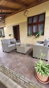 a patio with wicker chairs and a table at Falusi ház Tóth György in Bajša