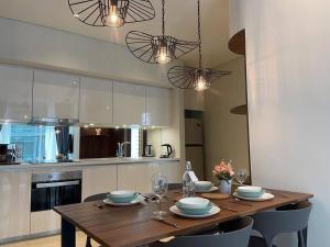 a kitchen with a wooden table with chairs and lights at Deluxe Apartment Across KLCC in Kuala Lumpur +4 photos