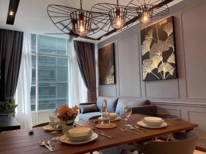 a dining room with a table and a chandelier at Deluxe Apartment Across KLCC in Kuala Lumpur