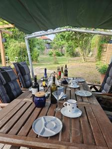 a wooden table with wine bottles and plates on it at Joes Cottage in Lackenbach