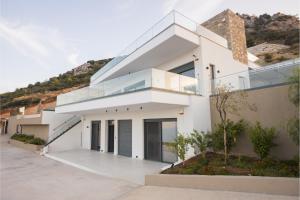 a white house with a hill in the background at Panoramic Villa in Tolo