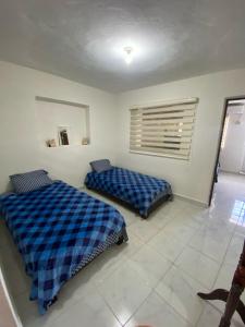 a bedroom with two beds and a window at Departamento vacacional in Mazatlán