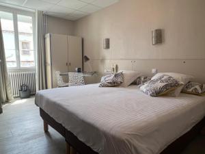 a bedroom with a large bed with white sheets and pillows at L'Artimon by les Ambassadeurs - Saint Malo Plage in Saint Malo