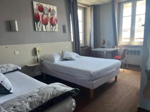 a bedroom with two beds and a table and chairs at L'Artimon by les Ambassadeurs - Saint Malo Plage in Saint Malo