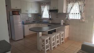 a kitchen with a counter and a sink and a refrigerator at Bayview Selfcatering Apartment in Hartenbos