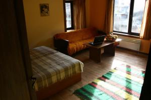 a room with a bed and a laptop on a table at Guesthouse KaraIvan in Arda