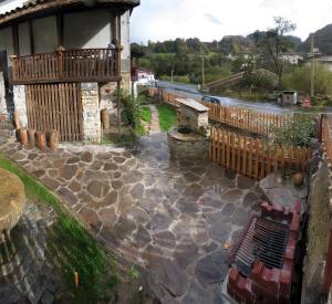 un patio en pierre avec une clôture en bois et un bâtiment dans l'établissement Guesthouse KaraIvan, à Arda