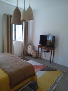 une chambre avec un lit, une télévision et une table dans l'établissement Villa Bohèmia, à Essaouira