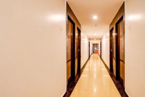 a long hallway with wooden doors and a long floor at Collection O by OYO Flavour in Āsansol