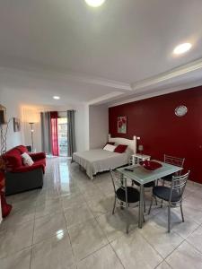 un salon avec un lit, une table et des chaises dans l'établissement Apartamento balcón esquina, à Puerto de la Cruz