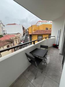 un balcon avec une table et des chaises sur un immeuble dans l'établissement Apartamento balcón esquina, à Puerto de la Cruz