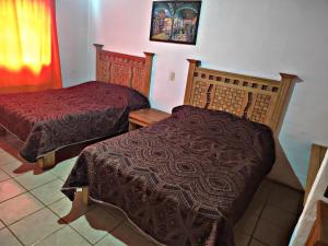 Un dormitorio con dos camas y un cuadro en la pared. en Cabaña D' Torres, en Mazamitla 12 fotos más