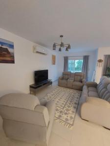 a living room with two couches and a tv at Villa Mountain View North Coast ماونتن فيو رأس الحكمه in Ras Elhekma