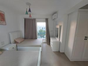 a white room with two beds and a window at Villa Mountain View North Coast ماونتن فيو رأس الحكمه in Ras Elhekma