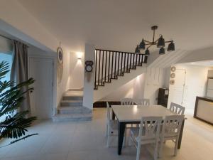 a dining room with a table and chairs and a staircase at Villa Mountain View North Coast ماونتن فيو رأس الحكمه in Ras Elhekma