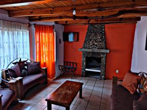 Una sala de estar con un sofá y una chimenea. en Cabaña D' Torres, en Mazamitla