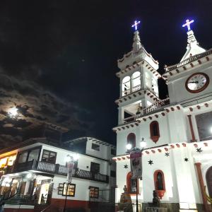 una iglesia blanca con una torre de reloj por la noche en Cabaña D' Torres, en Mazamitla