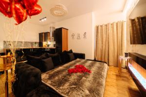 a living room with a black couch with red roses on it at Casa Amor - Adult Only Jacuzzi Suite in Southampton