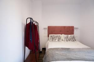 a bedroom with a bed and a red coat on the wall at LA CARRERA 7 - "San Ildefonso" - Parking sujeto a disponibilidad in Jaén