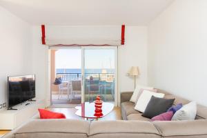 a living room with a couch and a table with a television at Portopiccolo Apartments Rubino nel Borgo in Sistiana