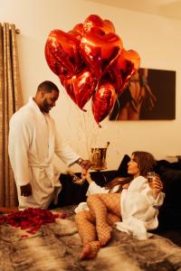 a man giving a woman a bunch of heart balloons at Casa Amor - Adult Only Jacuzzi Suite in Southampton +9 photos