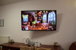 a television hanging on a wall with a table at Visovac Rooms in Skradin