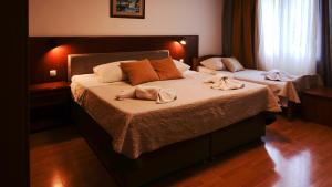 a bedroom with two beds with towels on them at Visovac Rooms in Skradin