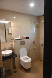 a bathroom with a toilet and a sink at Hotel Sai Yatri in Trimbak