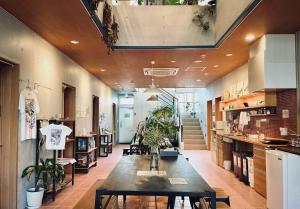 a large room with a table and some plants at HOSTEL SunTerrace Ishigaki in Ishigaki Island
