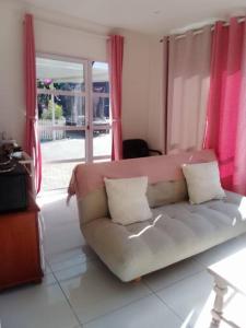 a living room with a couch in front of a window at Bright and Sunny Studio Cottage in Durban