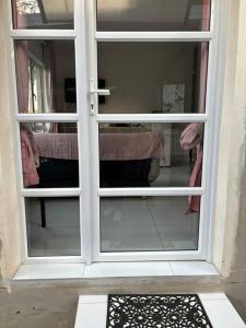 a door with a window in a room at Bright and Sunny Studio Cottage in Durban