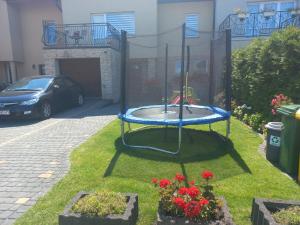 a playground in a yard with a car parked at Robi pokoje i apartament in Łeba
