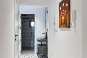 a hallway with a bathroom with a sink and a mirror at La Carrera 7 - Baños Árabes - Parking sujeto a disponibilidad in Jaén +35 photos