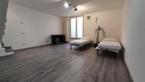 una stanza vuota con due letti e un pianoforte di Gentle House a Cavallasca