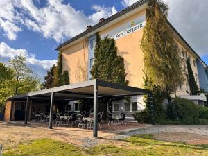 a view of the front of the hotel with tables and chairs at Hotel am Tierpark in Güstrow
