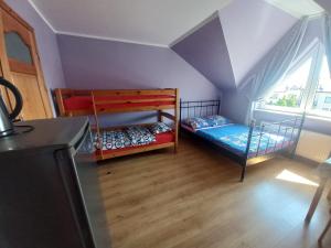 a room with two bunk beds and a kitchen at Robi pokoje i apartament in Łeba