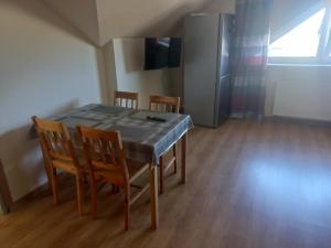 a dining room table with chairs and a refrigerator at Robi pokoje i apartament in Łeba +21 photos