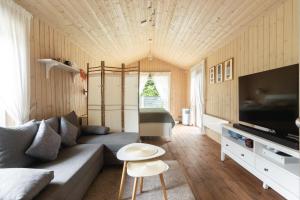 a living room with a couch and a table at Romantic Holiday House Nandi Rezidence Janupietis in Mellupi